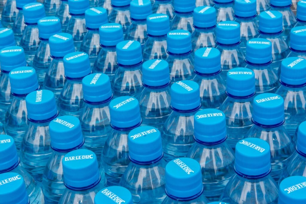Close-up of stacked plastic water bottles with blue caps, highlighting recycling and plastic use.