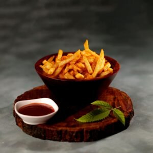 Appetizing French fries served with tangy dipping sauce on wooden board.